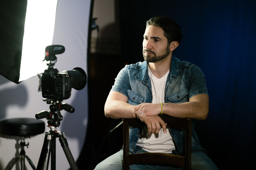 a man sitting in a chair in front of a camera.