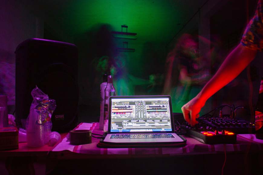 long exposure photo of a DJ using a laptop at a night club