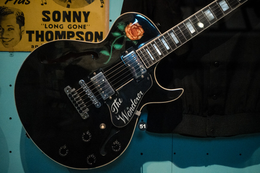 a black electric guitar with a rose on it.