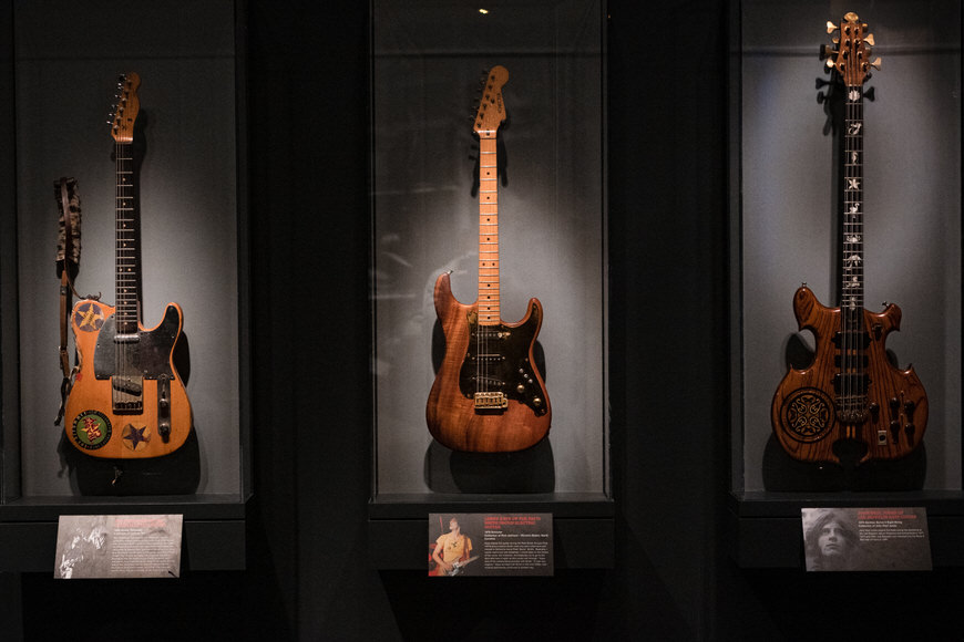 a group of guitars on display in a case.