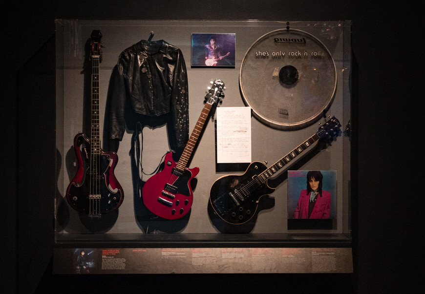 a display case with guitars and other musical instruments.