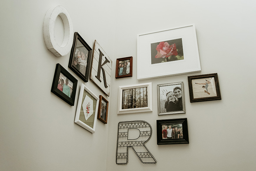 a wall with a bunch of framed pictures on it.