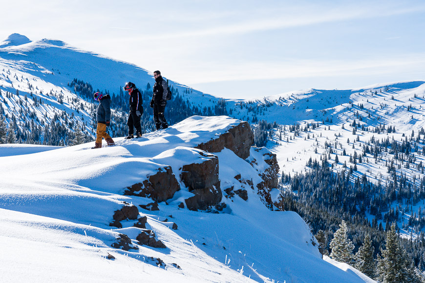 a group of people standing on top of a snow covered slope.