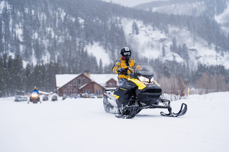 a person riding a snowmobile in the snow.