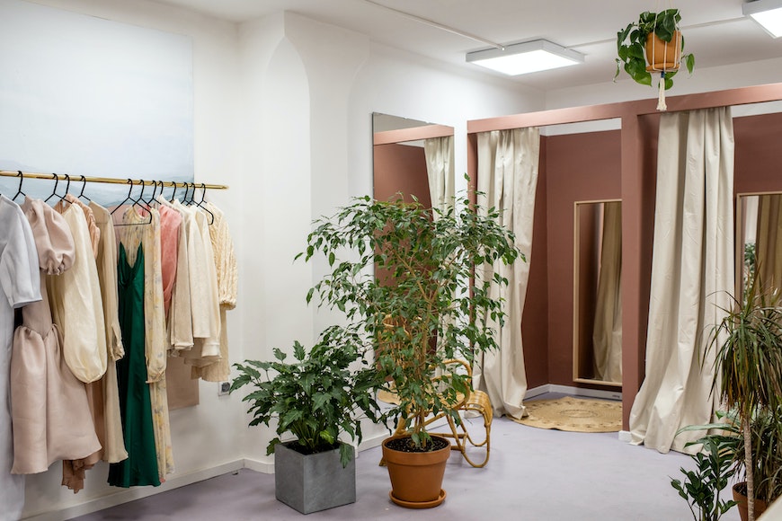 a room filled with lots of clothes and plants.
