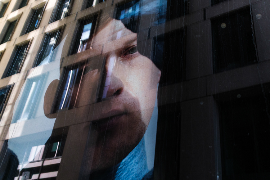 a reflection of a man on the side of a building.