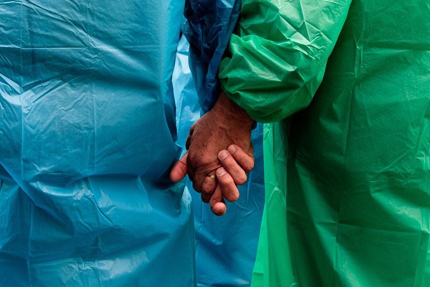 a close up of two people in blue and green medical gowns.