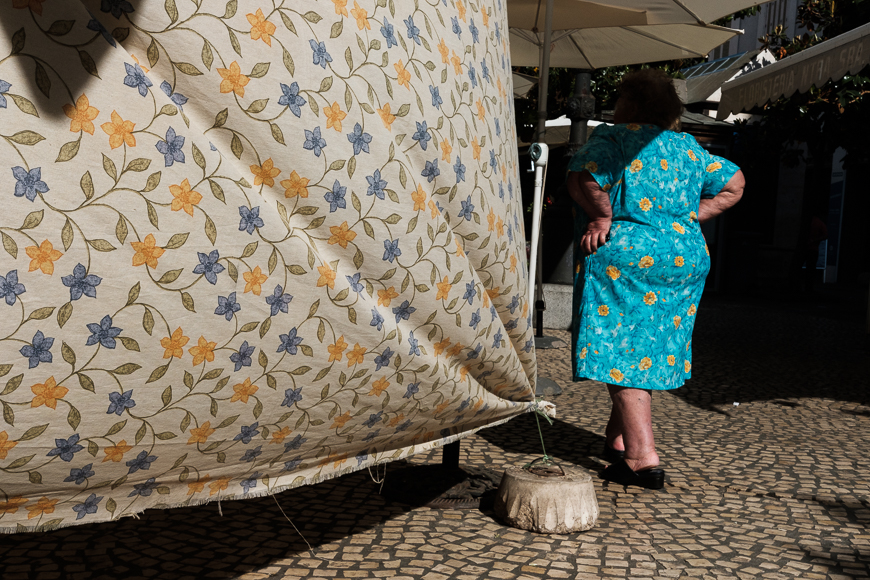 a woman in a blue dress standing next to a tent.