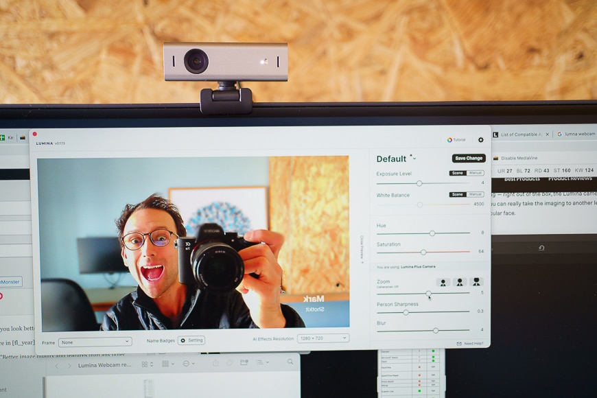 man testing webcam on screen holding camera