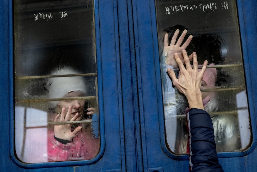 two people reaching out of a train window.