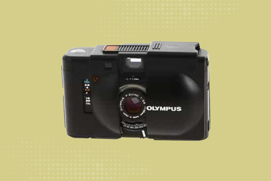 Olympus XA4 camera on a yellow background.