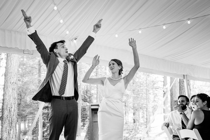 bridal couple throwing their arms in the air