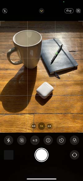 Screenshot of the iPhone camera app showing a cup of coffee and a notebook on a wooden table.