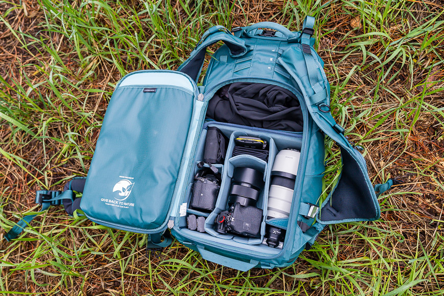 a camera bag is open on the ground.