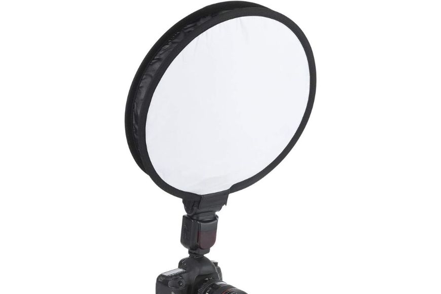 a camera with a flash light round diffuser attached to it.