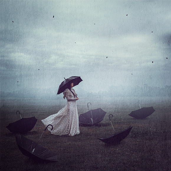 a woman in a white dress holding an umbrella.