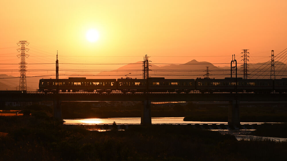 a train traveling over a bridge at sunset.