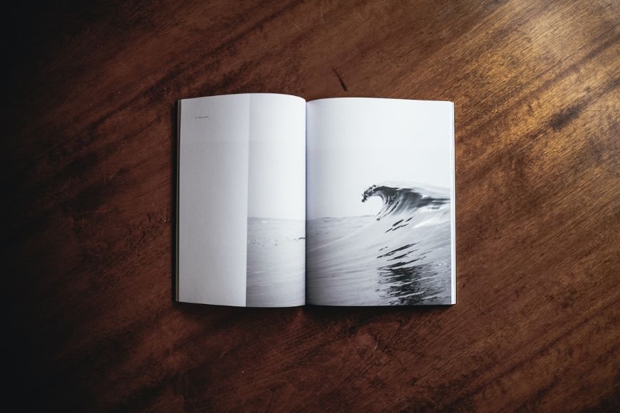 an open photo book with a picture of a wave on it.