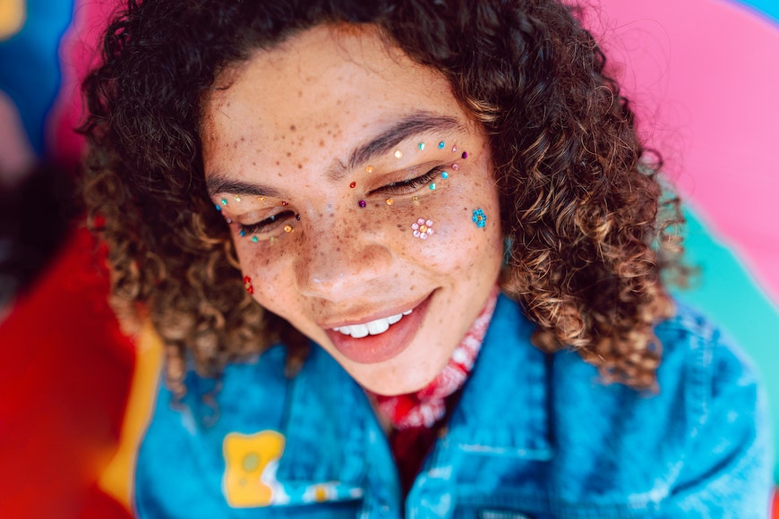 a girl with freckles and a colorful face.