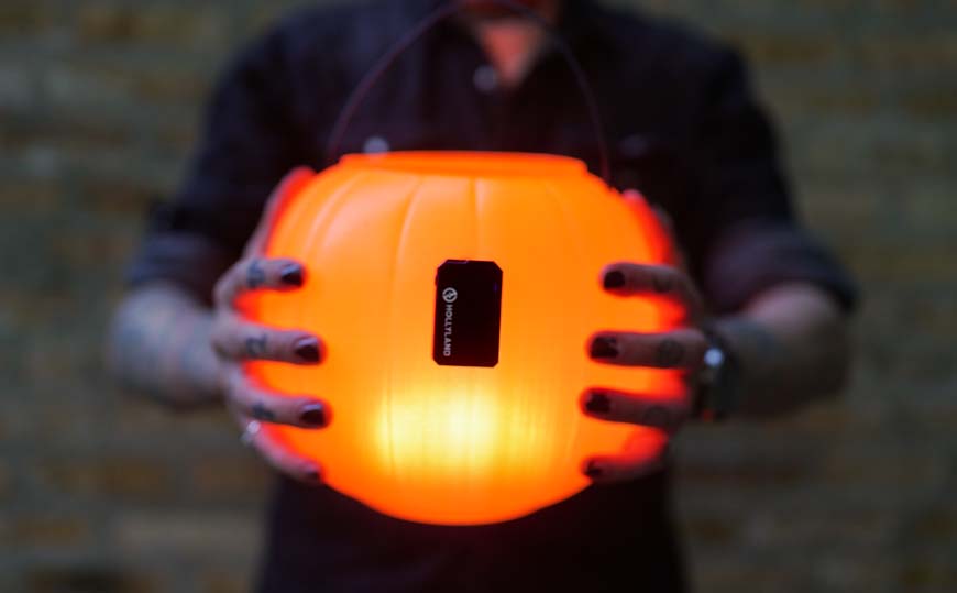 a person holding a glowing pumpkin in their hands.