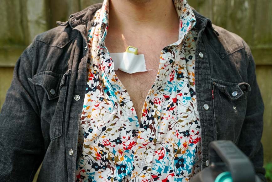a man wearing a flowered shirt with a lav mic taped to the shirt.