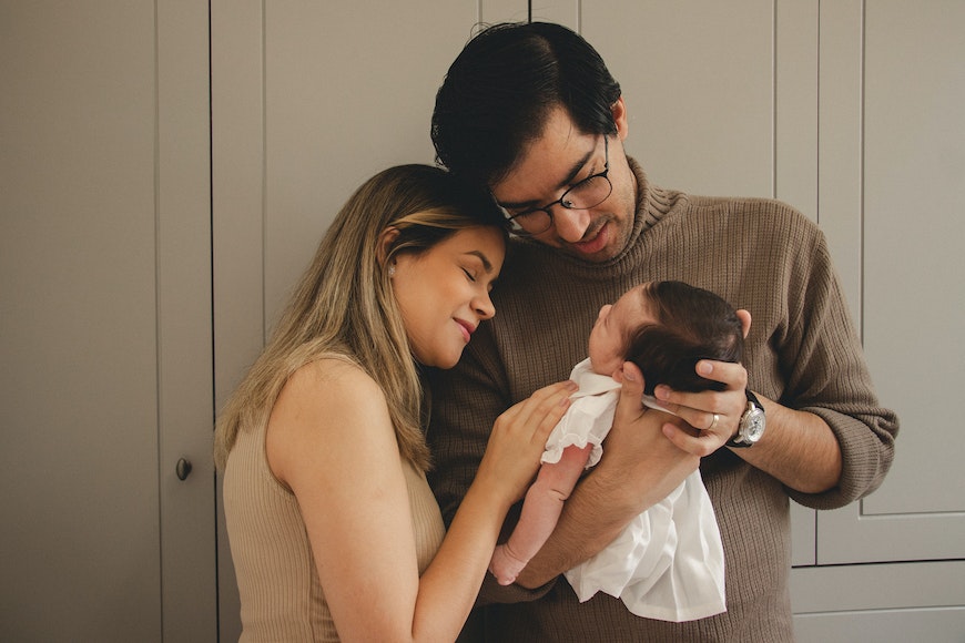 a man and a woman are holding a baby.