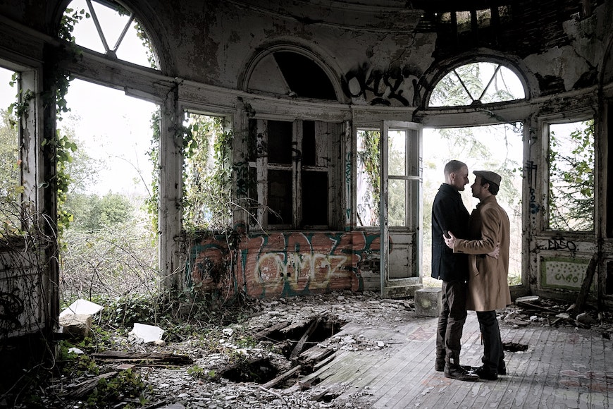 a man and woman are standing in an abandoned building.