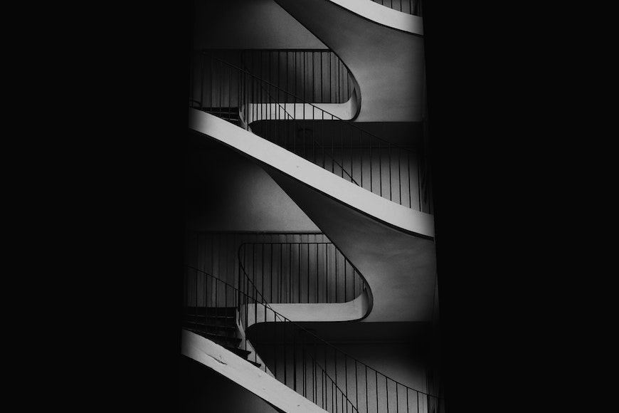 a black and white photo of a spiral staircase.