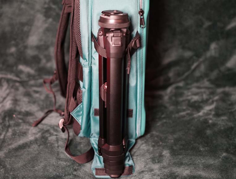 a close up of a camera tripod in a backpack.