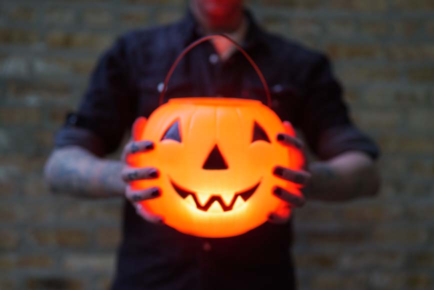 a man holding a glowing pumpkin in his hands.
