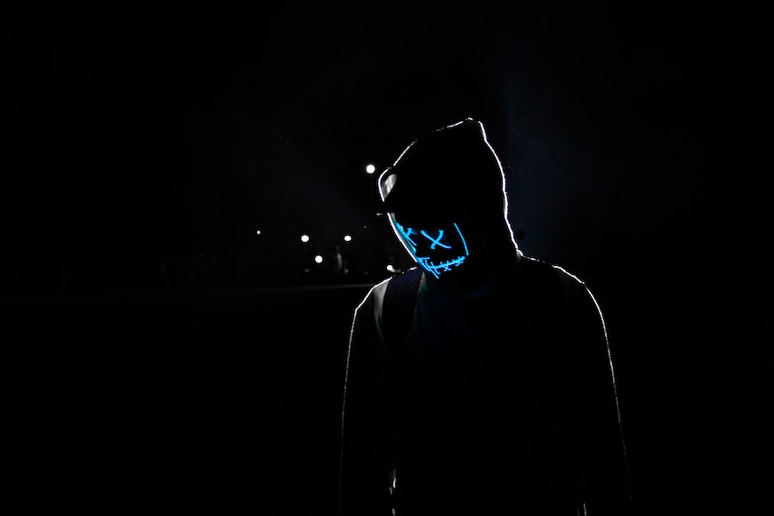 a man wearing a mask in the dark.