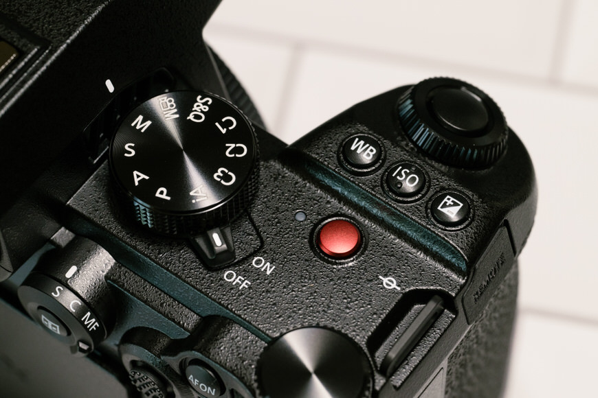 a close up of a camera with a red button.