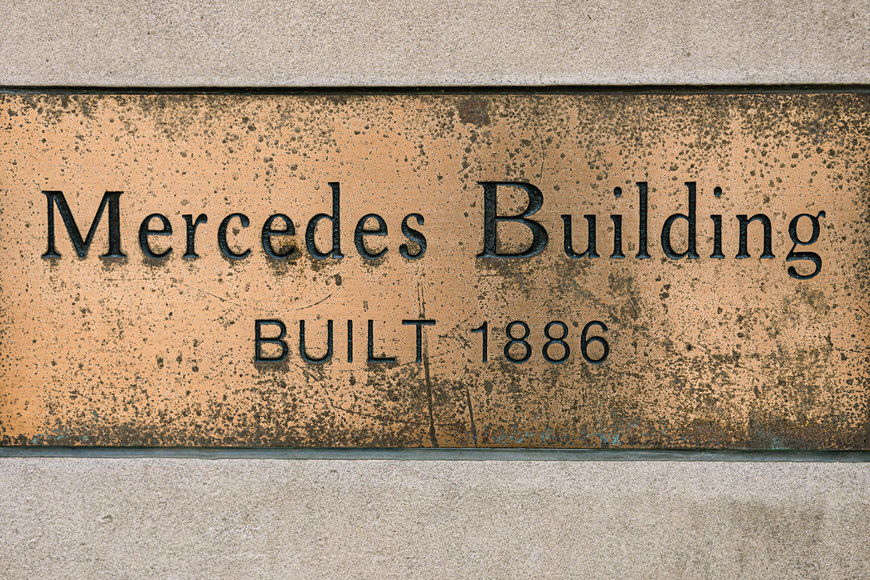 a sign that says mercedes building built 1886.