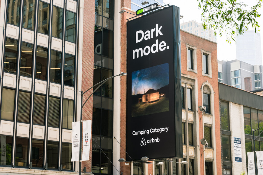 a billboard advertising dark mode on the side of a building.
