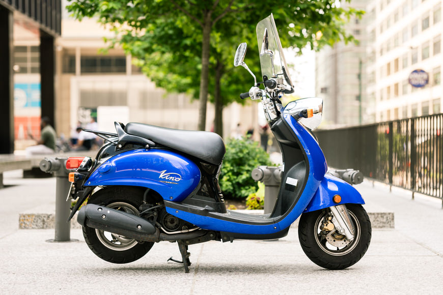 a blue scooter is parked in front of a building.