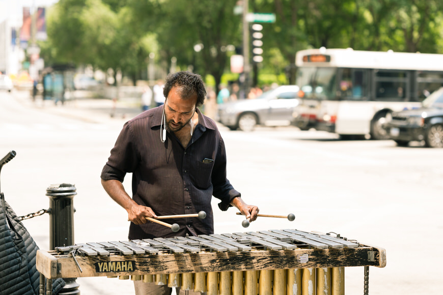 a man playing a xylophone on the street.