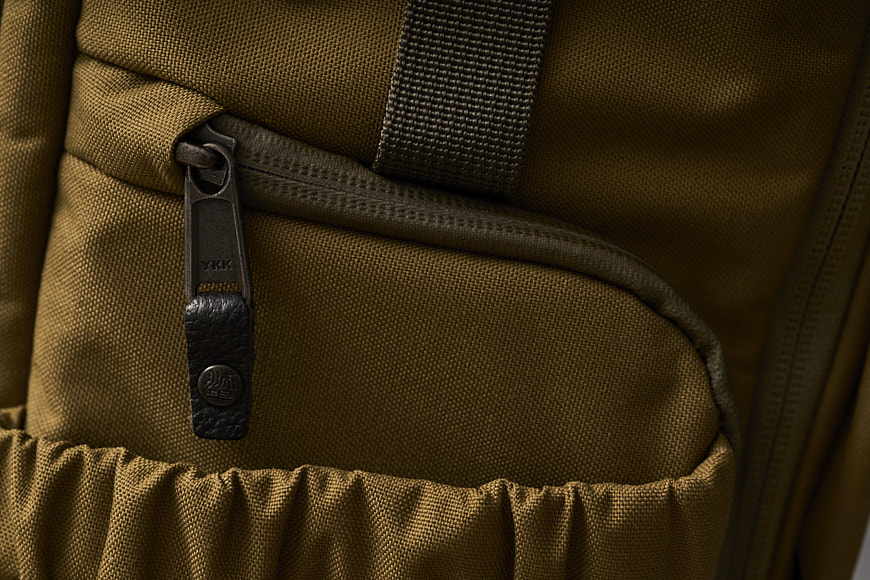 a close up of a brown backpack with a zipper.