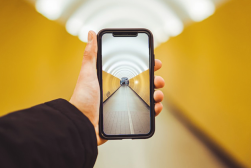 a person holding up a cell phone in a tunnel.
