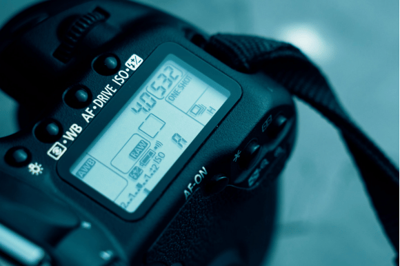 a close up of a dslr camera with a strap.