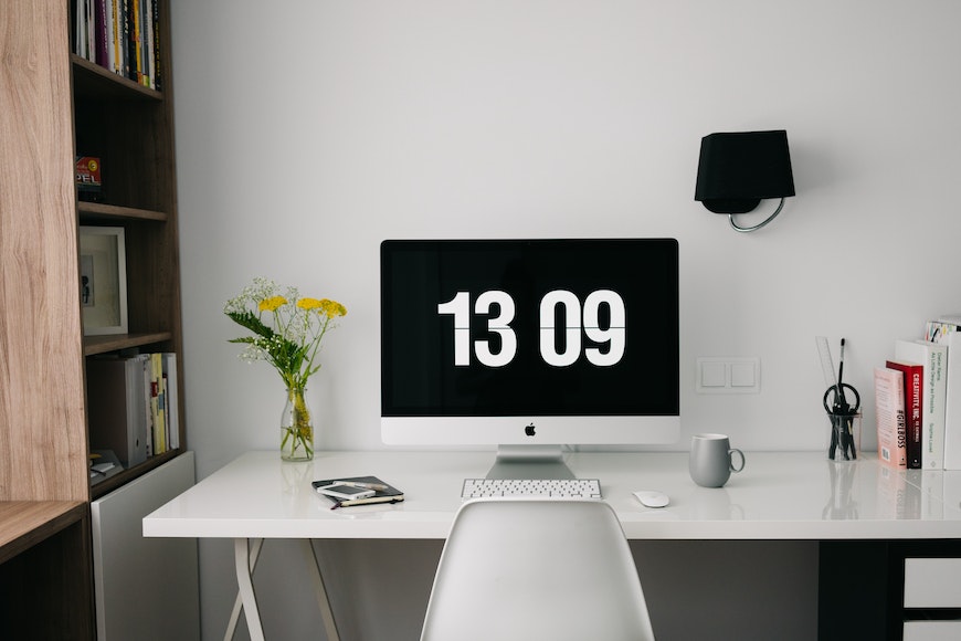 a white desk with a clock on it.