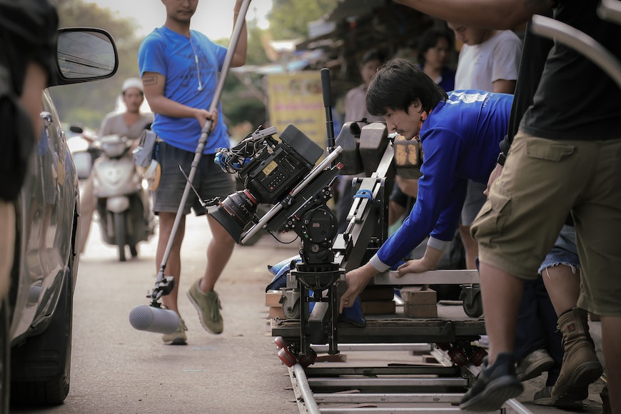 a group of people on a set with a camera.
