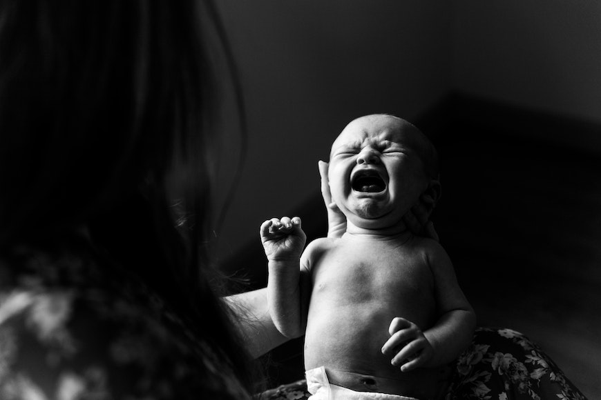 a black and white photo of a baby crying.