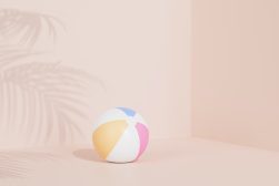 a beach ball sitting on a pink background.