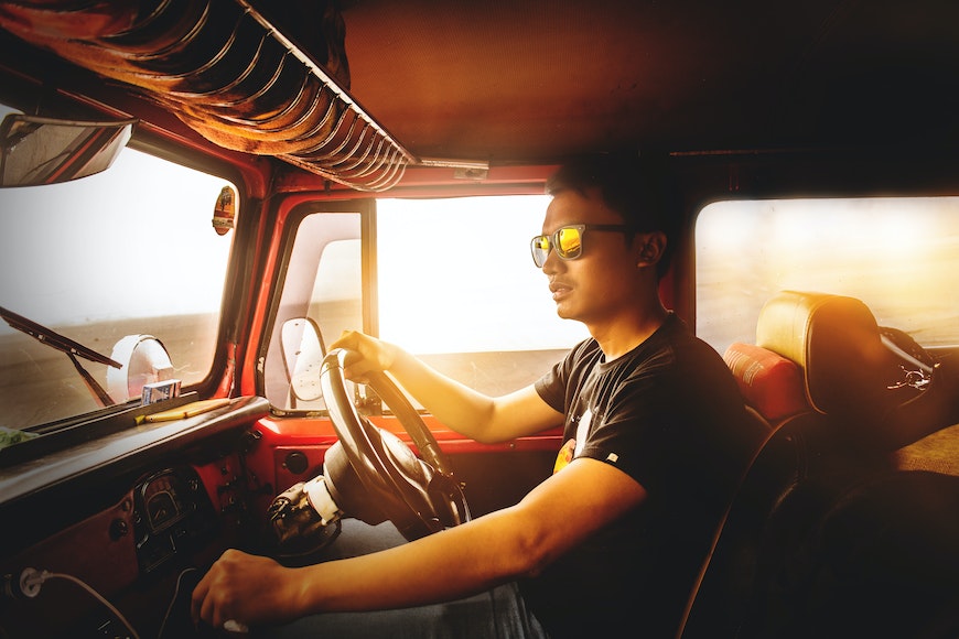 a man driving a truck with sunglasses on.