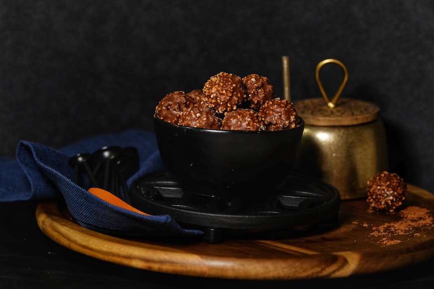 chocolate balls in a bowl on a wooden plate.
