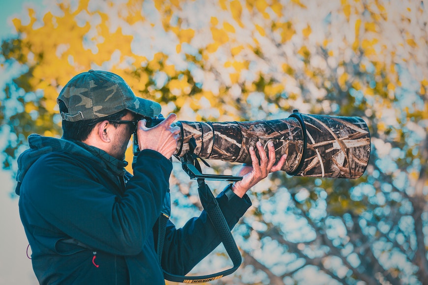 a man is taking a picture with a camouflaged camera.