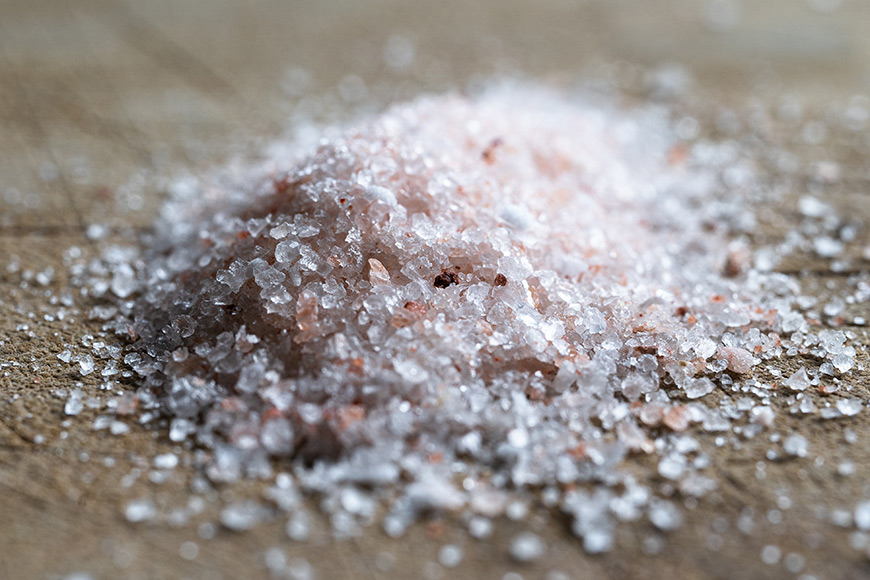 A pile of pink salt on a wooden surface.