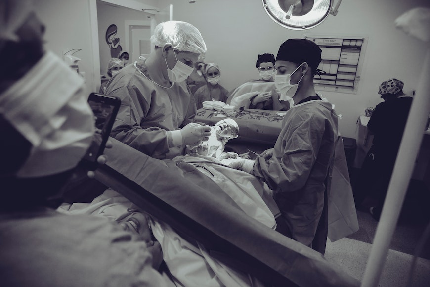 a group of surgeons working on a patient in an operating room.