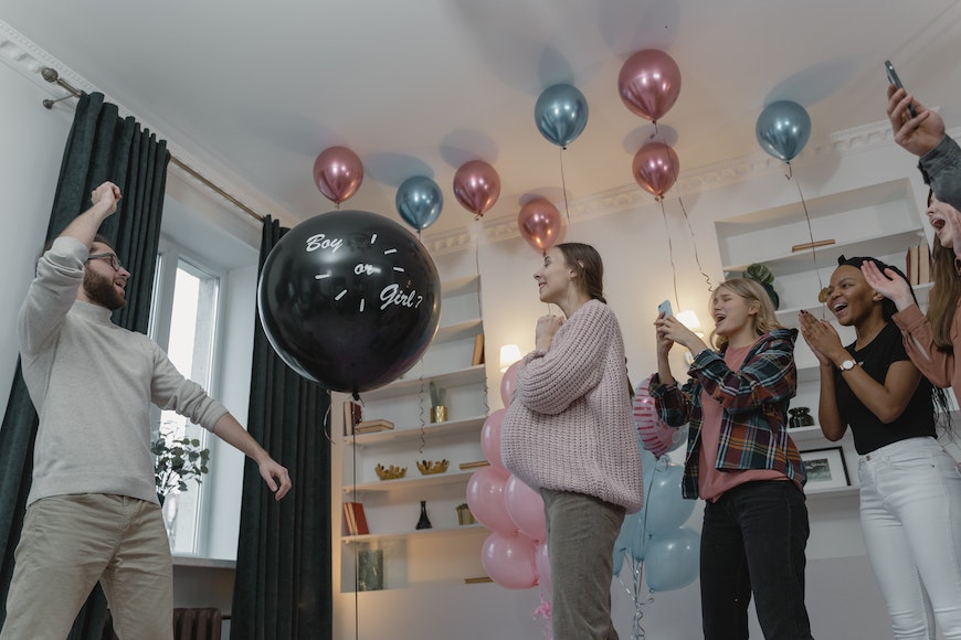a group of people holding balloons in a living room.