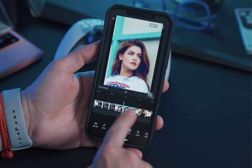 A person holding a phone with a picture of a woman on it.